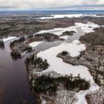 Vue aérienne d’un cours d’eau sinueux traversant un paysage enneigé