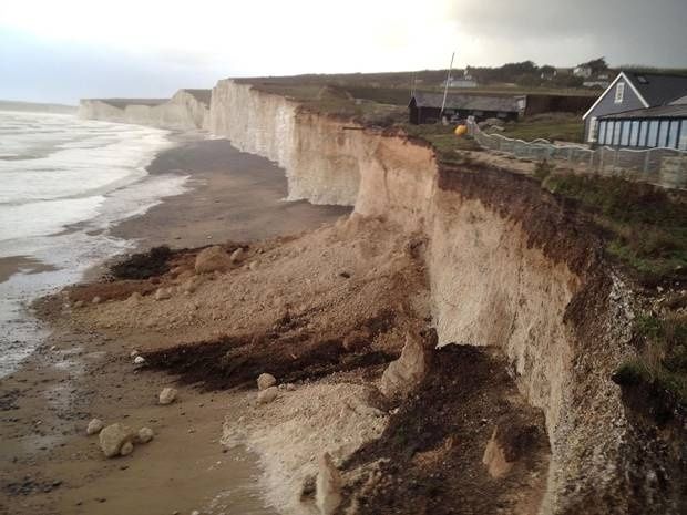Falaise côtière fortement érodée au pied d’habitations